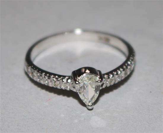 A modern 14ct white gold and pear shaped single stone diamond ring, with diamond set shoulders, size L.